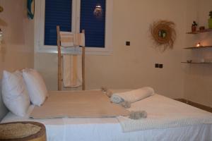 a bedroom with a bed with white sheets and a window at west wave surf house in Tamraght Ouzdar