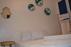 a bedroom with two clocks on the wall and a bed at west wave surf house in Tamraght Ouzdar