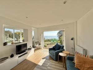 a living room with a blue chair and a television at 1 East Cliff in Lyme Regis