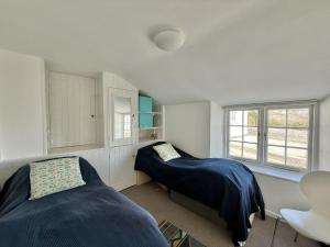 a bedroom with two beds and a window at 1 East Cliff in Lyme Regis