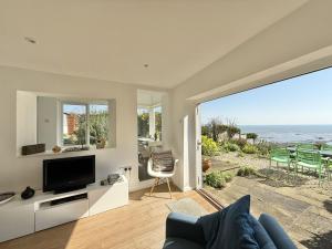 a living room with a tv and a view of the ocean at 1 East Cliff in Lyme Regis