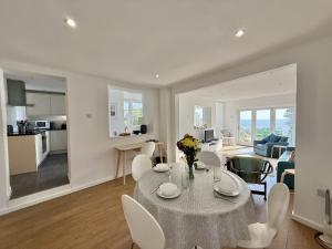 a dining room and living room with a table and chairs at 1 East Cliff in Lyme Regis