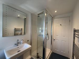 a bathroom with a shower and a sink and a mirror at 1 East Cliff in Lyme Regis +35 photos