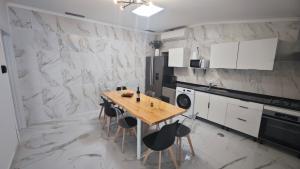 a kitchen with a wooden table and black chairs at Cascais Garden House in Cascais