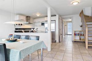 a kitchen and dining room with a table and chairs at 0230-Romo-Havnebyvej-61-E in Høm