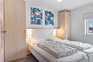 a bedroom with a bed and two paintings on the wall at 0230-Romo-Havnebyvej-61-E in Høm