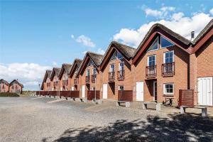 a row of brick buildings in a parking lot at 0230-Romo-Havnebyvej-61-E in Høm