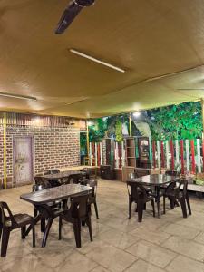 a restaurant with tables and chairs and a mural at Shree Savali Cottage in Revadanda