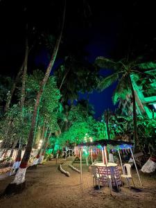 a group of chairs and tables on a beach at night at Shree Savali Cottage in Revadanda