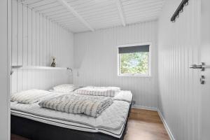 a white bedroom with a large bed with pillows at 2600-Romo-Vestergardsvej-18 in Høm