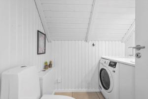 a white laundry room with a washing machine at 2600-Romo-Vestergardsvej-18 in Høm