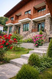 a building with stairs and flowers in front of it at Fortuna Cottage Bakuriani in Bakuriani