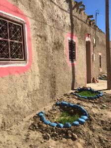 a wall with blue stones on the side of a building at Merzouga Hostel in Merzouga +34 photos