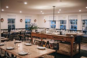 ein Esszimmer mit Tischen, Stühlen und Fenstern in der Unterkunft The Wildset in Saint Michaels