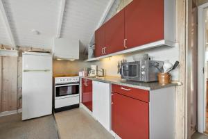 a kitchen with red and white cabinets and a microwave at 0389-Romo-Vestergade-3-Ap-77 in Høm +18 photos