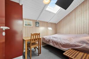 a bedroom with a bed and a table and a chair at 0389-Romo-Vestergade-3-Ap-77 in Høm