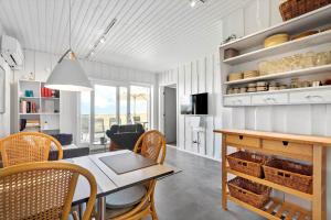 a dining room and living room with a table and chairs at 0295-Romo-Vestergade-3-68-E in Høm