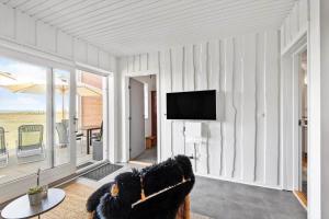 a living room with a tv and a couch and a table at 0295-Romo-Vestergade-3-68-E in Høm