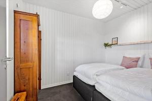 a bedroom with a bed and a wooden door at 0295-Romo-Vestergade-3-68-E in Høm