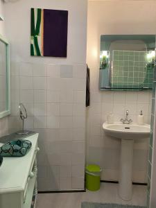 a small bathroom with a sink and a mirror at La suite Galerie d'ART in Céret