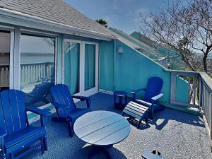 a deck with blue chairs and a table and a table and chairs at Cozy Coastal Repose in Padre Island