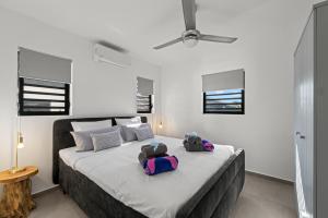 a bedroom with a large bed with two bags on it at Tropilena Resort in Willemstad +37 photos