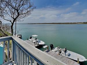a dock with a boat on the water at Cozy Coastal Repose in Padre Island