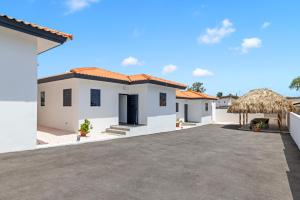 a white house with a large driveway at Tropilena Resort in Willemstad