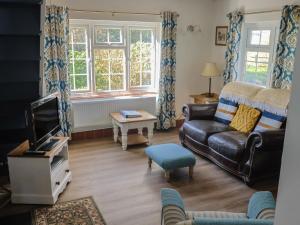 a living room with a couch and a tv at The Old Smithy in Bridport