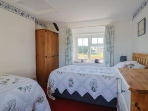 a bedroom with two beds and a window at The Old Smithy in Bridport