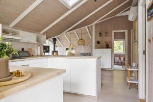 a kitchen with white cabinets and wooden ceilings at 0153-Romo-Julianehab-5 in Høm +26 photos