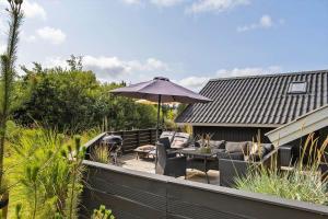 a patio with a table and an umbrella at 0153-Romo-Julianehab-5 in Høm