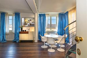a dining room with blue curtains and a table and chairs at Il Forte di Monic in Forte dei Marmi