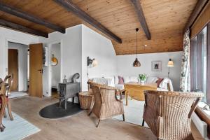 a living room with wooden ceilings and rattan chairs at 0199-Romo-Lejrbjergvej-32 in Høm