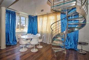 a spiral staircase in a room with a table and chairs at Il Forte di Monic in Forte dei Marmi