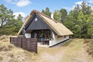 a small house with a thatched roof with a table at 0199-Romo-Lejrbjergvej-32 in Høm