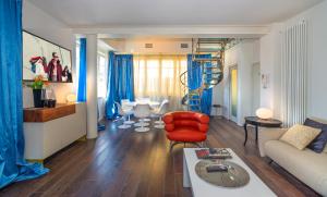 a living room with a couch and a red chair at Il Forte di Monic in Forte dei Marmi