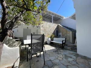 a patio with a table and a bench next to a building at Lemon House in Hydra
