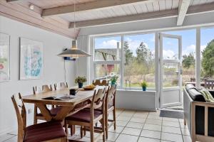 a dining room with a wooden table and chairs at 0185-Romo-Rabjergvej-82 in Høm
