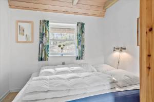 a large white bed in a room with a window at 0185-Romo-Rabjergvej-82 in Høm