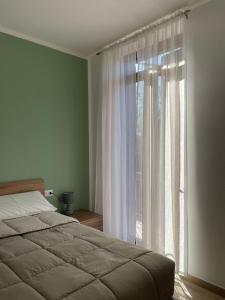a bedroom with a bed and a large window at Antico Ticino Malpensa in Lonate Pozzolo