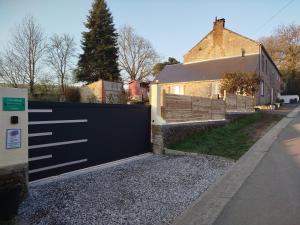 a black garage door in front of a house at Gite Au Fil du Temps in Walcourt