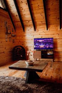 a living room with a table and a tv at Refúgio dos Capitéis Cabana in Farroupilha