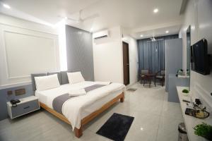a bedroom with a large white bed and a bathroom at Manasa Comforts Boarding and Lodging Karkala in Kārkāl