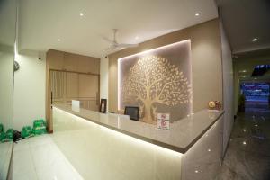 a lobby with a tree mural on the wall at Manasa Comforts Boarding and Lodging Karkala in Kārkāl +6 photos