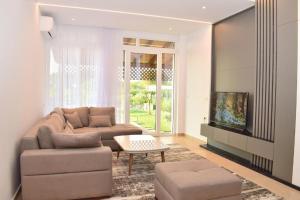 a living room with a couch and a table at Garden apartment in Vala Mar in Hamallë