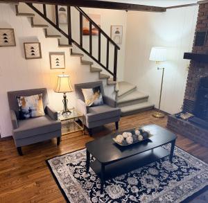 a living room with two chairs and a staircase at The Cozy Chalet in Asheville