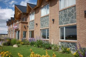 una fila de edificios con flores delante de ellos en Marcopolo Suites Calafate en El Calafate