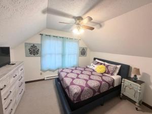 a bedroom with a purple bed and a ceiling fan at The Cozy Chalet in Asheville +12 photos
