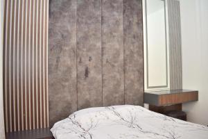 a bedroom with a bed and a mirror at Garden apartment in Vala Mar in Hamallë